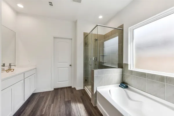 a bathroom with a tub sink and mirror