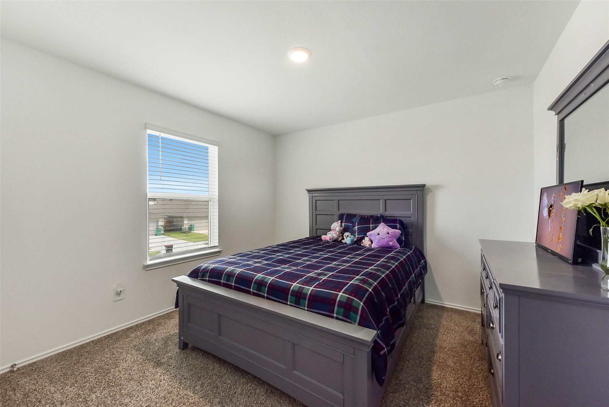 4985 Blue Beetle Rdg Drive Katy, TX 77493 - Photo 28 of 40 a bedroom with a bed and a flat tv screen on a dresser