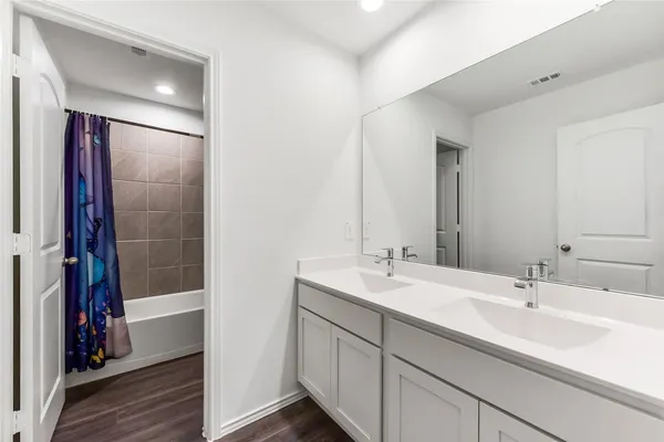 a bathroom with a double vanity sink and a mirror