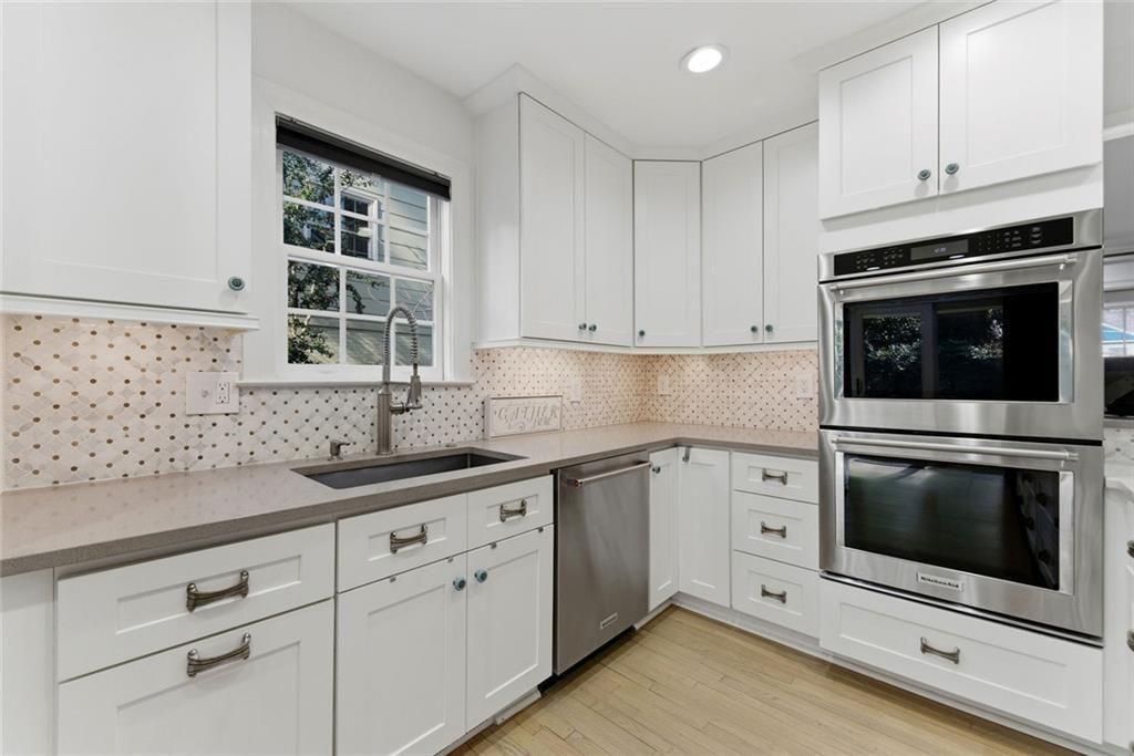 302 Hascall Road Northwest Atlanta, GA 30309 - Photo 12 of 56 a kitchen with granite countertop white cabinets stainless steel appliances and sink