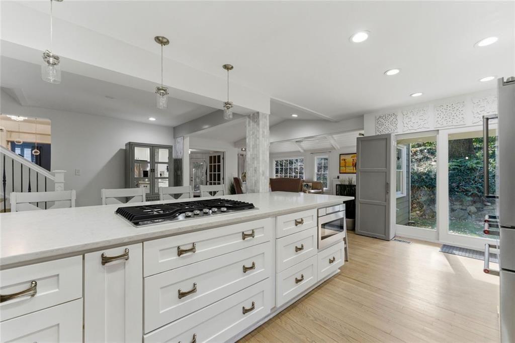 302 Hascall Road Northwest Atlanta, GA 30309 - Photo 13 of 56 a kitchen with stainless steel appliances kitchen island granite countertop a stove a sink a refrigerator and white cabinets with wooden floor