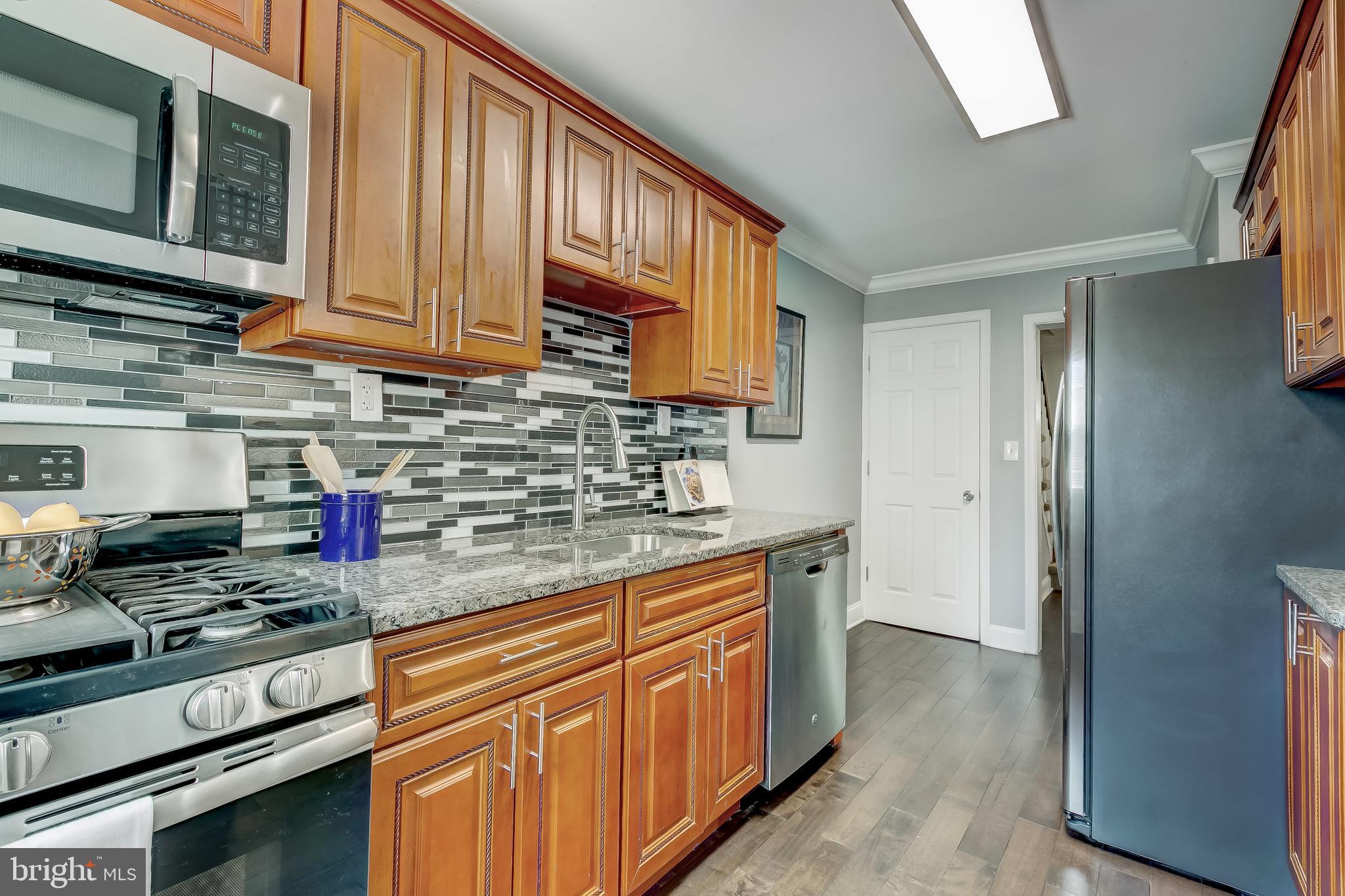 1419 Kingsway Road Baltimore, MD 21218 - Photo 12 of 38 a kitchen with stainless steel appliances granite countertop a sink stove and cabinets