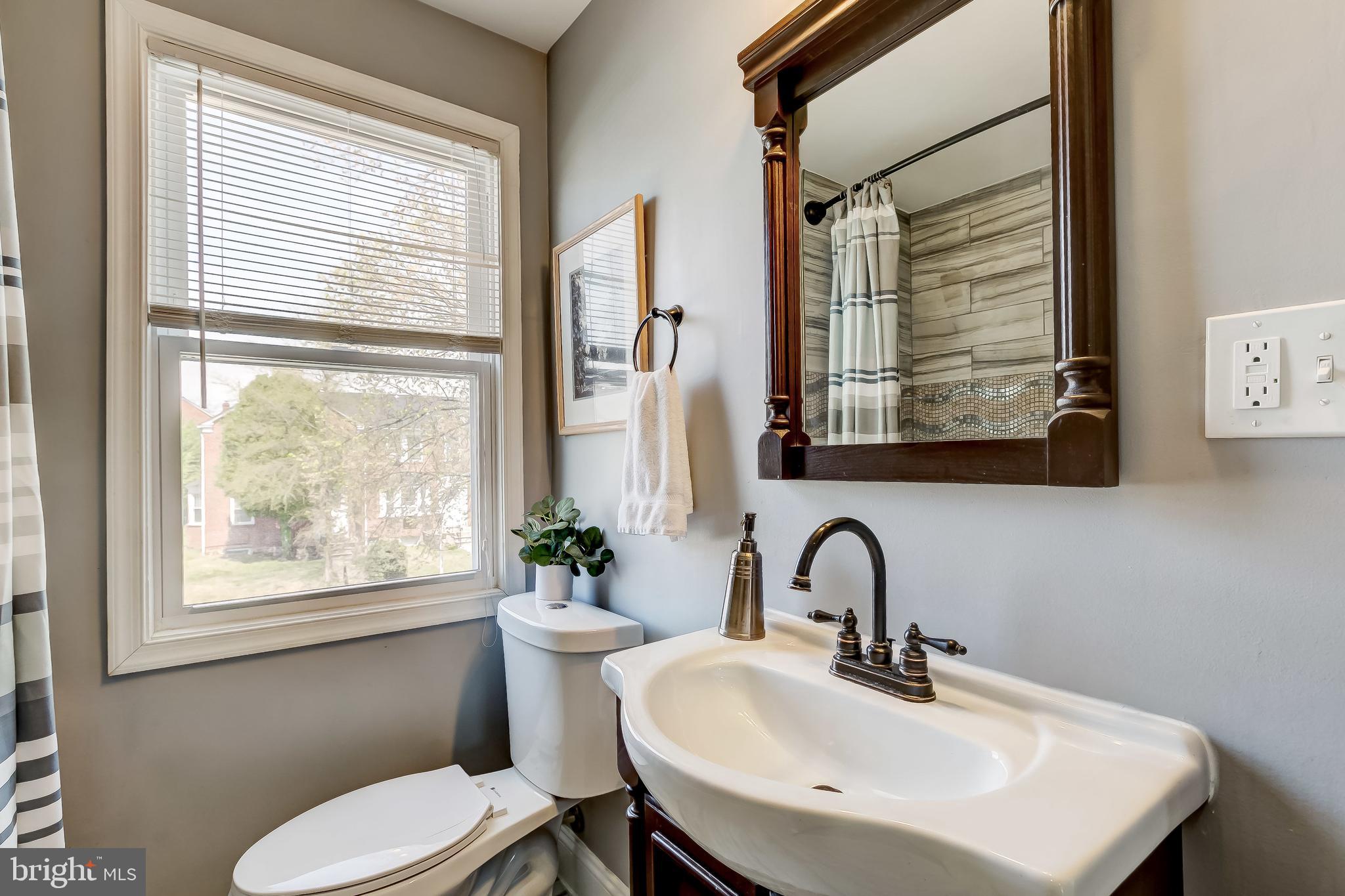 1419 Kingsway Road Baltimore, MD 21218 - Photo 21 of 38 a bathroom with a sink a toilet and a window