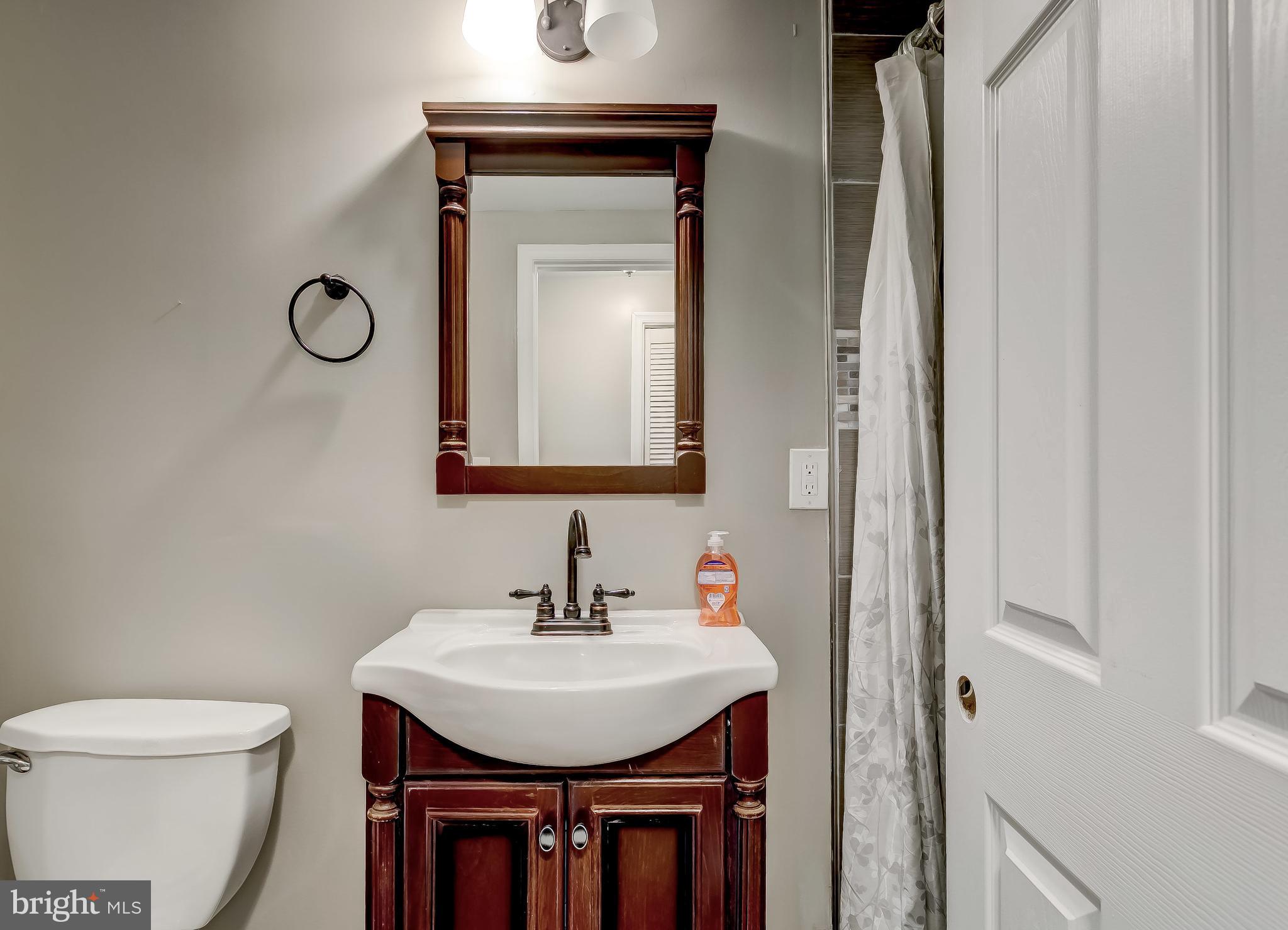1419 Kingsway Road Baltimore, MD 21218 - Photo 31 of 38 a bathroom with a toilet a sink and mirror