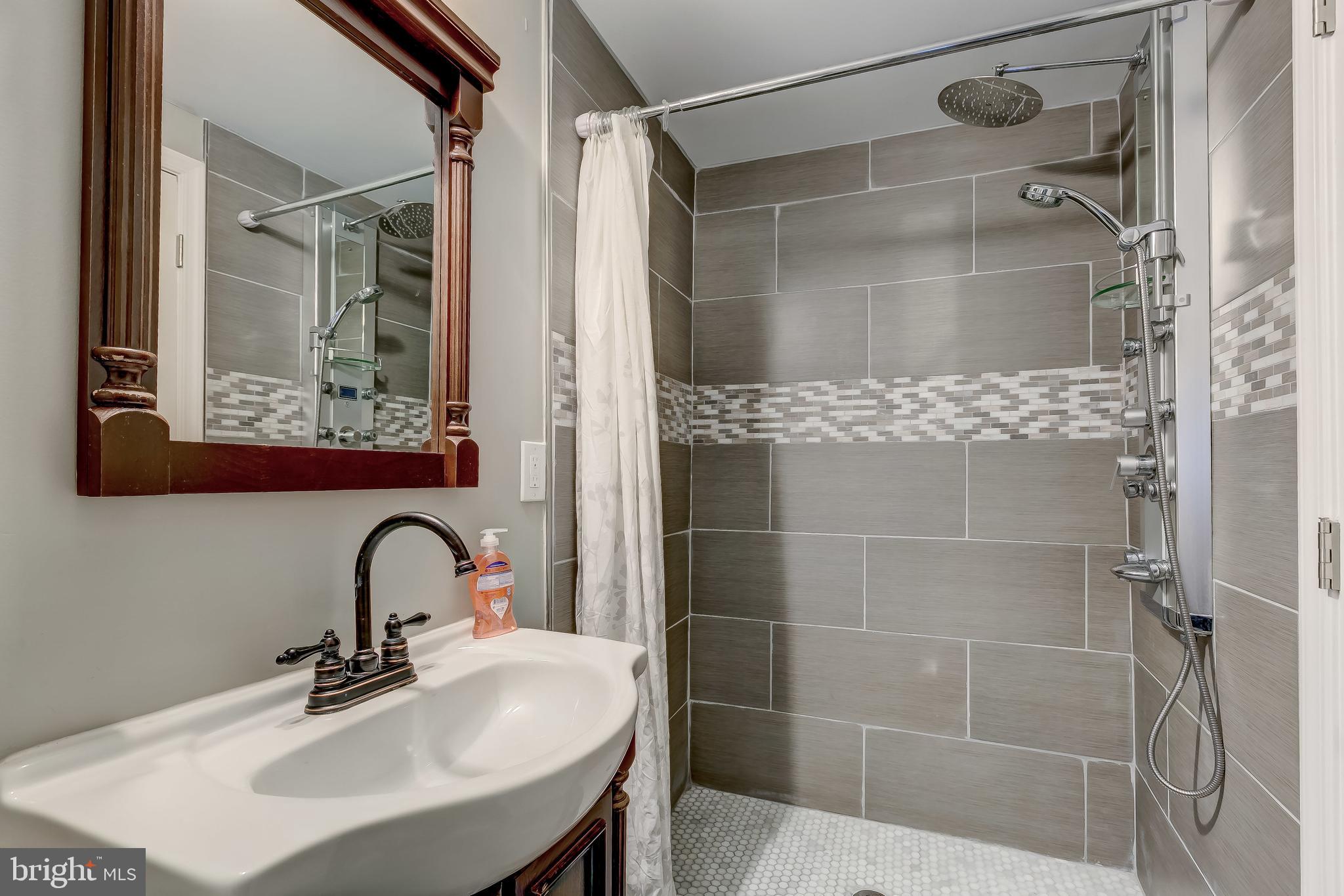 1419 Kingsway Road Baltimore, MD 21218 - Photo 32 of 38 a bathroom with a sink mirror and shower