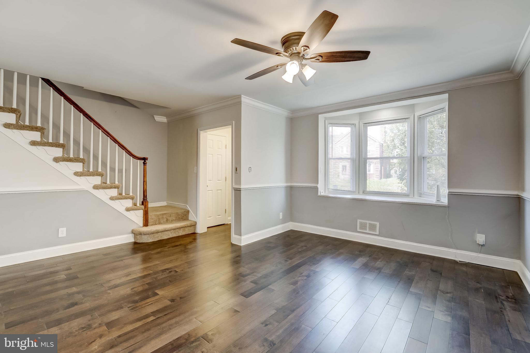 1419 Kingsway Road Baltimore, MD 21218 - Photo 7 of 38 a view of an empty room with wooden floor and a window