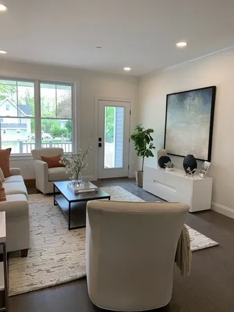 a living room with fireplace furniture and a large window