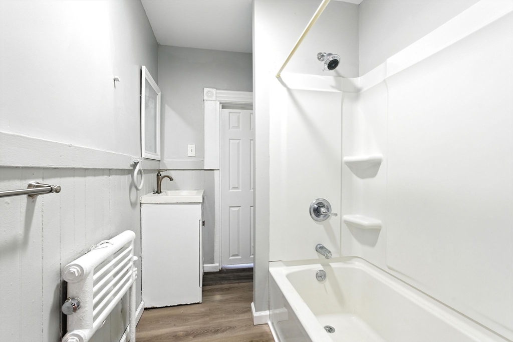 58 Governor Street Springfield, MA 01104 - Photo 13 of 23 a bathroom with a bathtub a sink a toilet and a mirror
