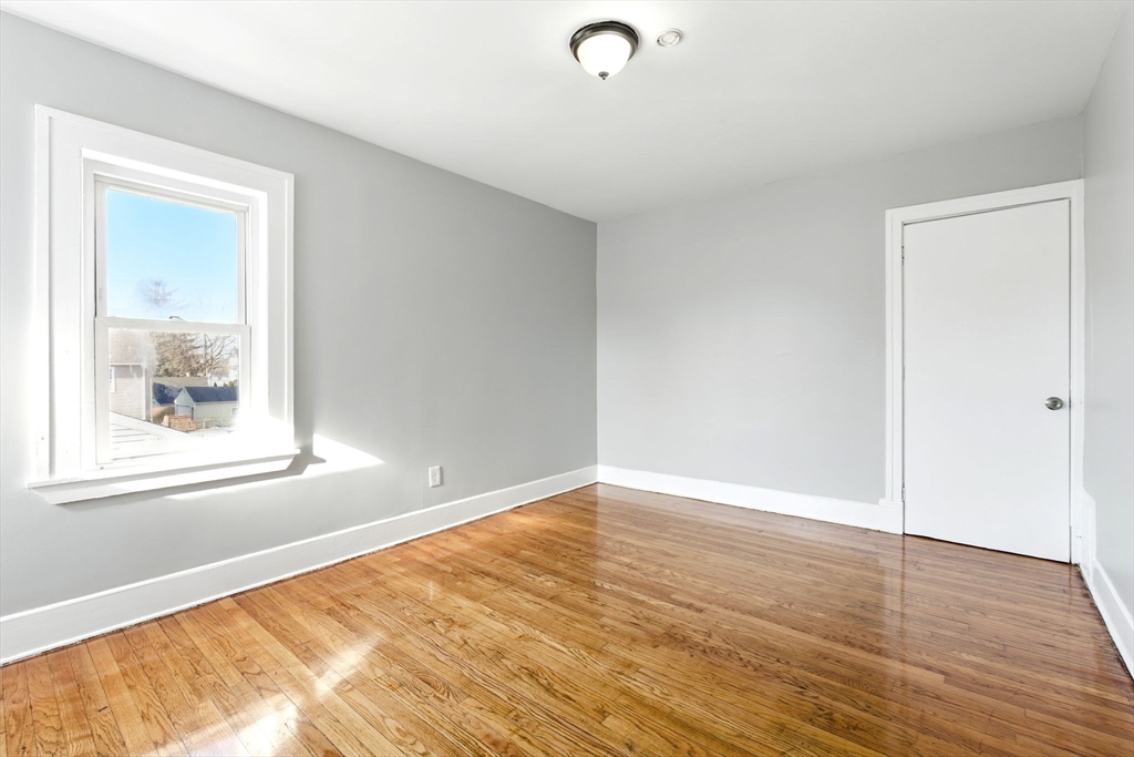 58 Governor Street Springfield, MA 01104 - Photo 14 of 23 a view of an empty room with wooden floor and a window