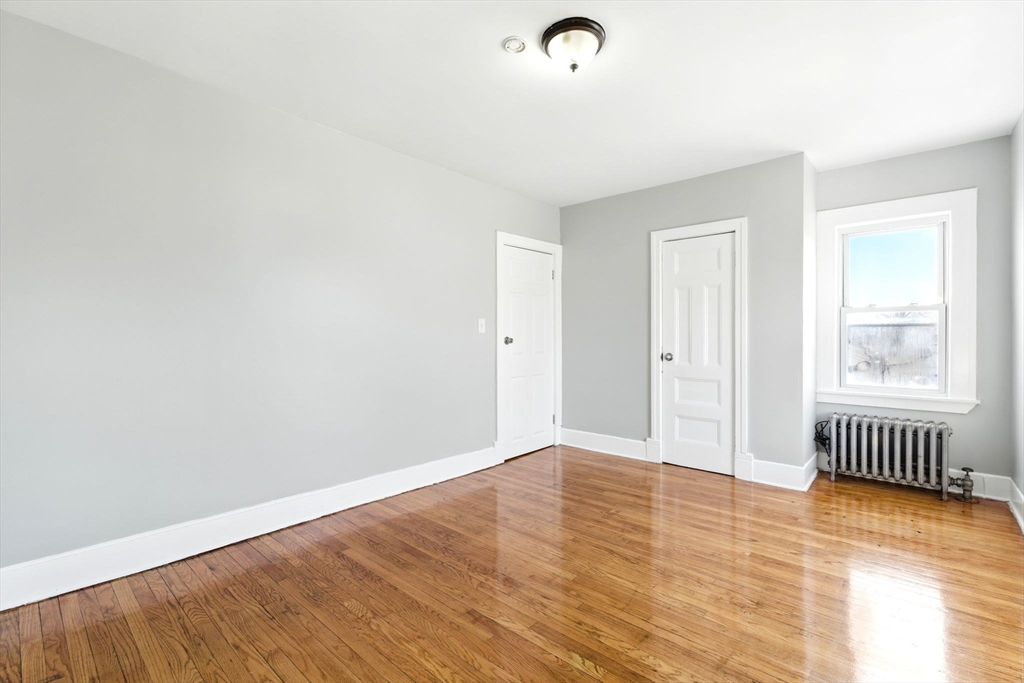 58 Governor Street Springfield, MA 01104 - Photo 16 of 23 an empty room with wooden floor and windows