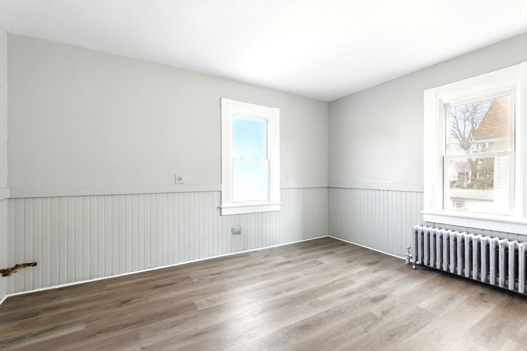 58 Governor Street Springfield, MA 01104 - Photo 8 of 23 an empty room with wooden floor and windows