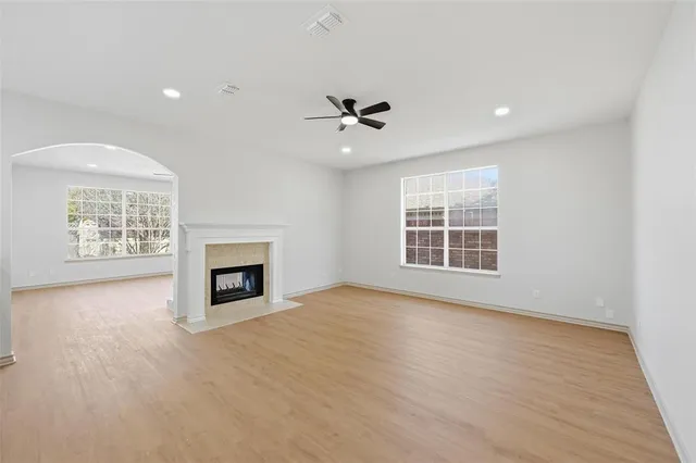 an empty room with windows and fireplace
