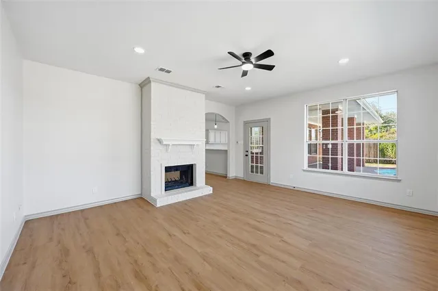 a view of an empty room with a fireplace and a window