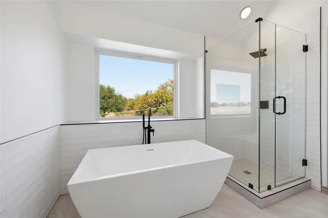 a white bath tub sitting next to a shower