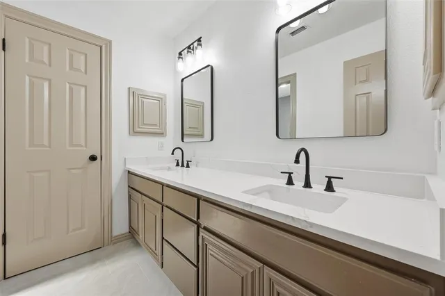 a bathroom with double sink and a mirror