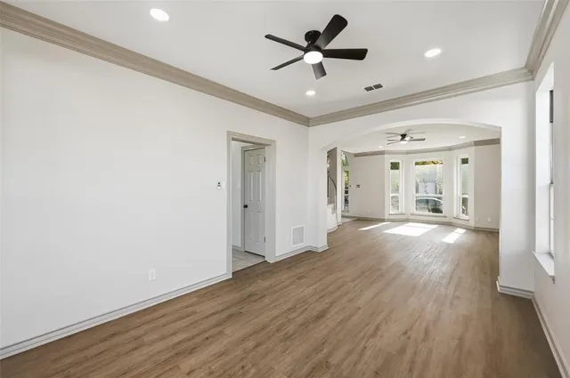 a view of a big room with wooden floor and a ceiling fan