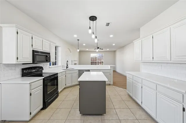 a kitchen with stainless steel appliances granite countertop a sink counter space cabinets and a center island