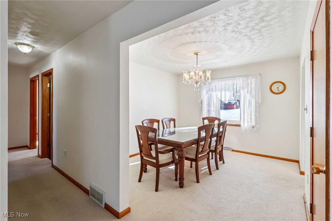 970 Eastern Road Doylestown, OH 44230 - Photo 7 of 49 Dining room featuring light colored carpet and a chandelier