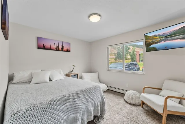 a bedroom with a bed and a painting on the wall