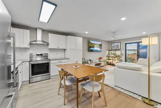 a kitchen with stainless steel appliances a stove a sink dishwasher a stove and a refrigerator with wooden floor