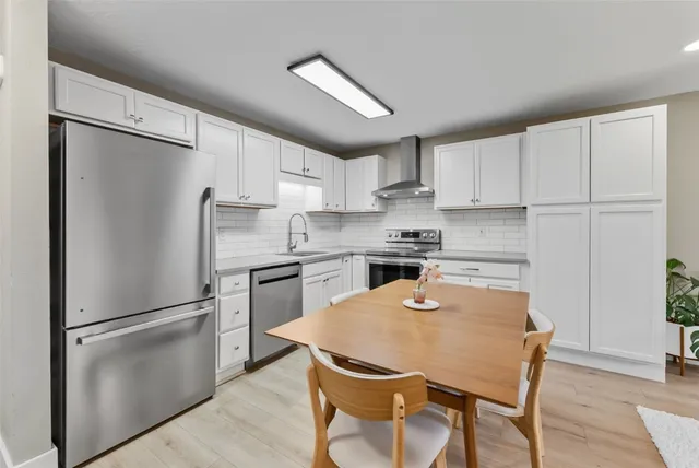 a kitchen with stainless steel appliances granite countertop a refrigerator sink and cabinets