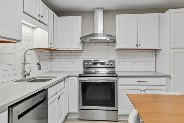 a kitchen with stainless steel appliances granite countertop a sink stove and cabinets