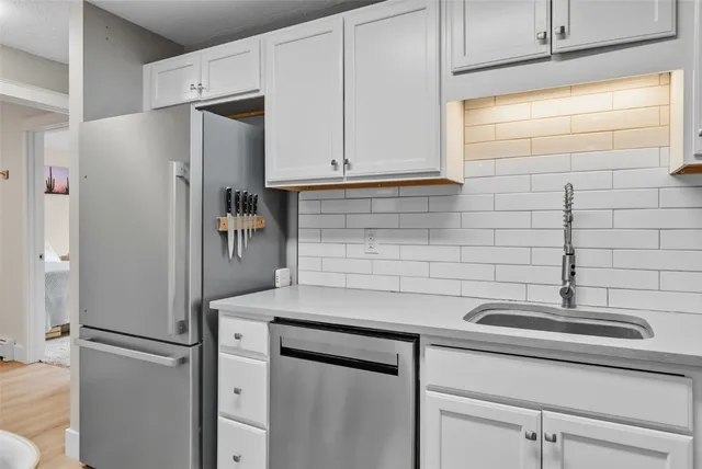 a kitchen with appliances a refrigerator and cabinets