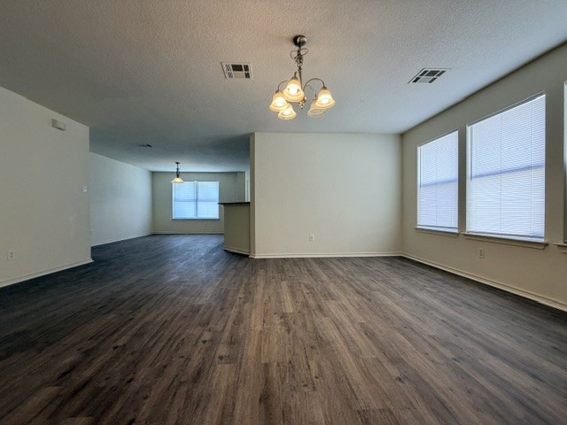 18421 Crestwind Lane Elgin, TX 78621 - Photo 8 of 34 Gleaming wood-look floors anchor this airy living space featuring large windows and a chandelier.