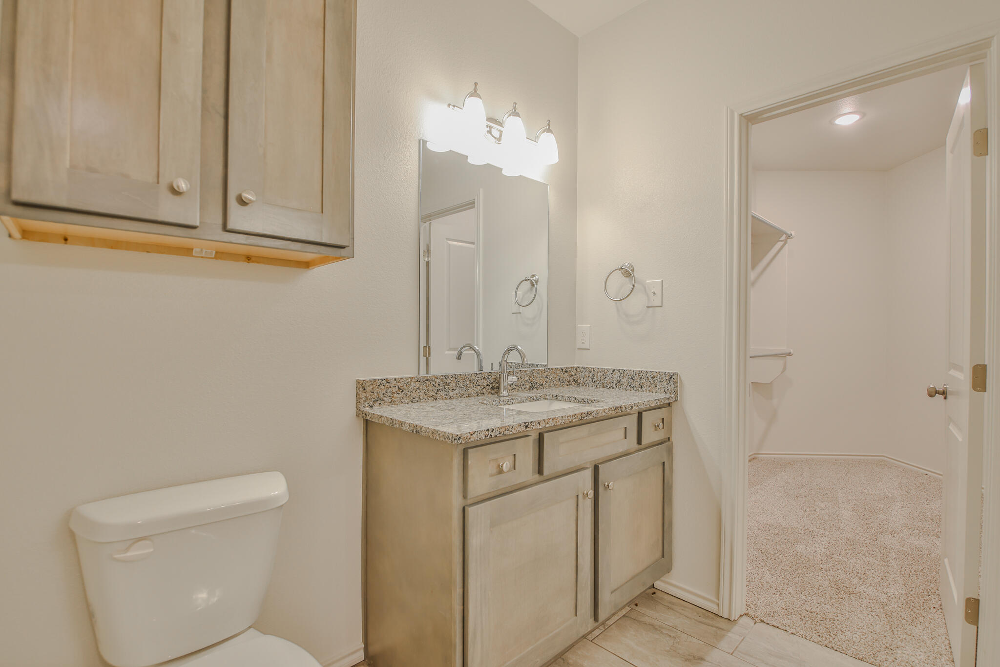 5512 Kemper Street Lubbock, TX 79416 - Photo 25 of 34 a bathroom with a granite countertop sink and a toilet