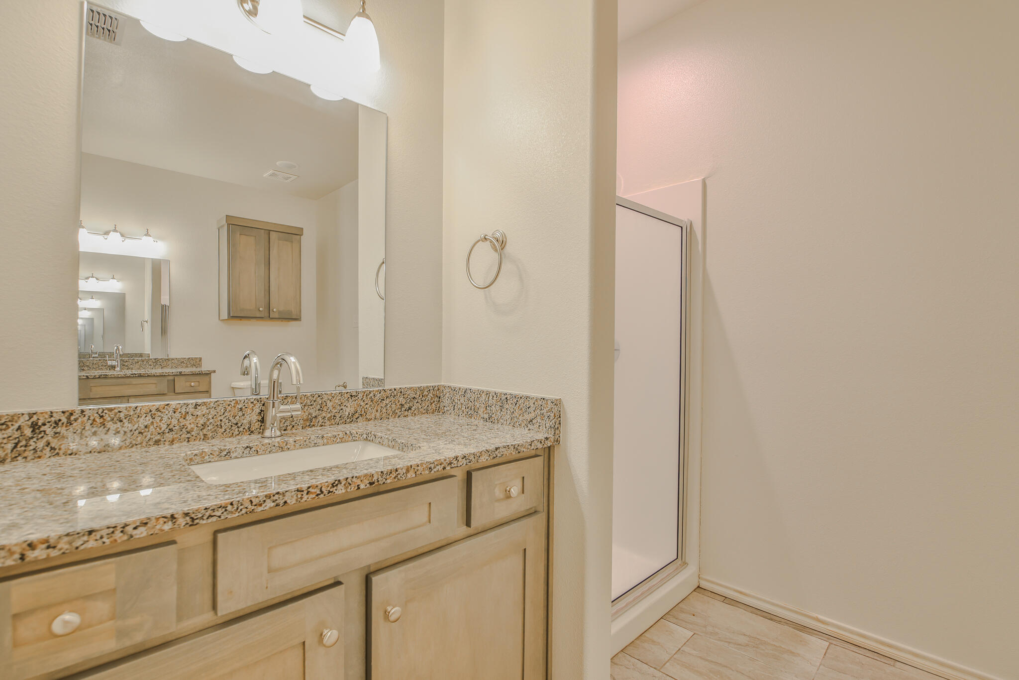 5512 Kemper Street Lubbock, TX 79416 - Photo 27 of 34 a bathroom with a granite countertop sink and a mirror