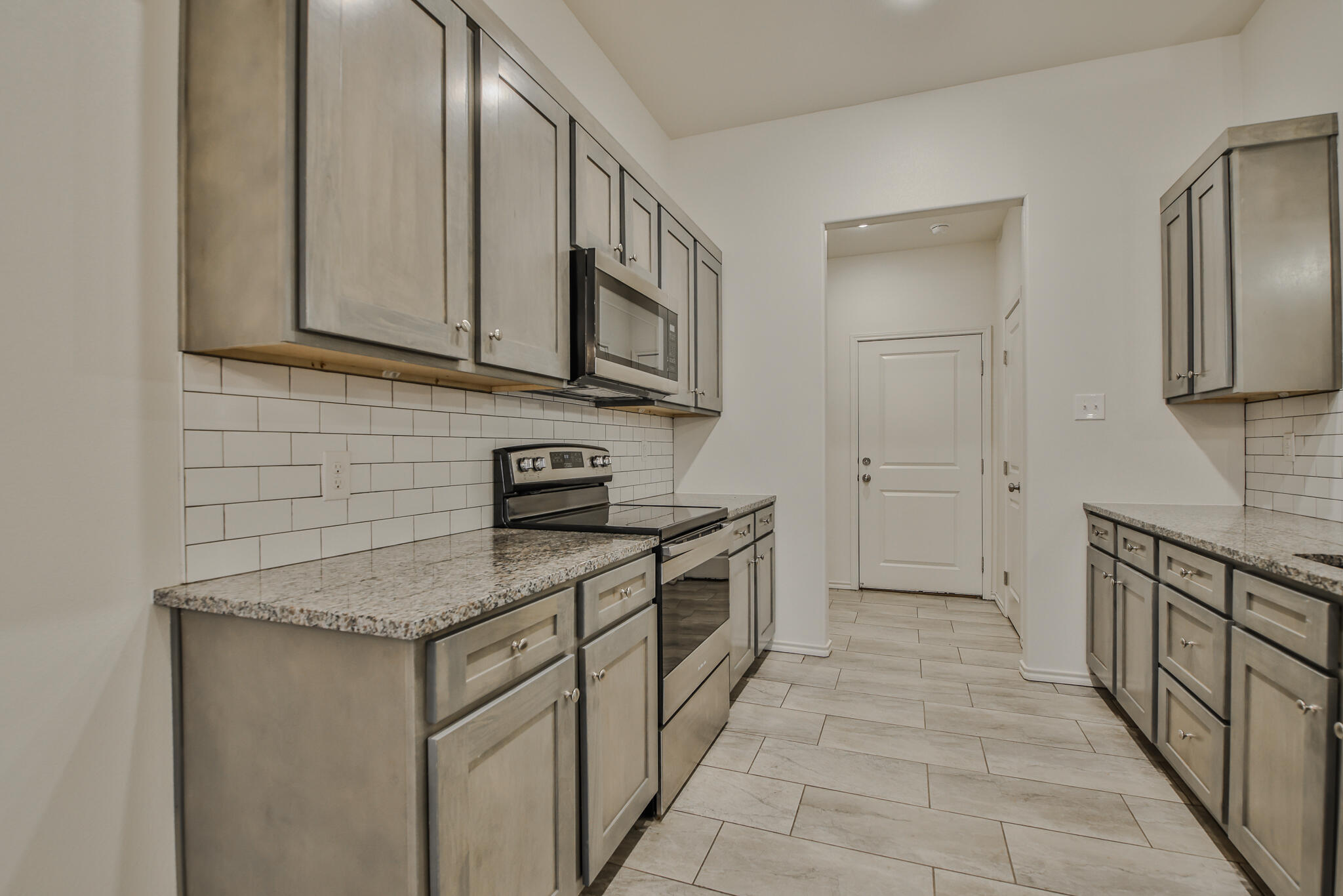 5512 Kemper Street Lubbock, TX 79416 - Photo 5 of 34 a kitchen with stainless steel appliances granite countertop a sink and a stove