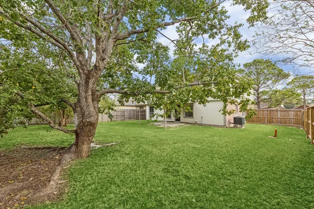 a view of a trees and barn in the middle of a yard