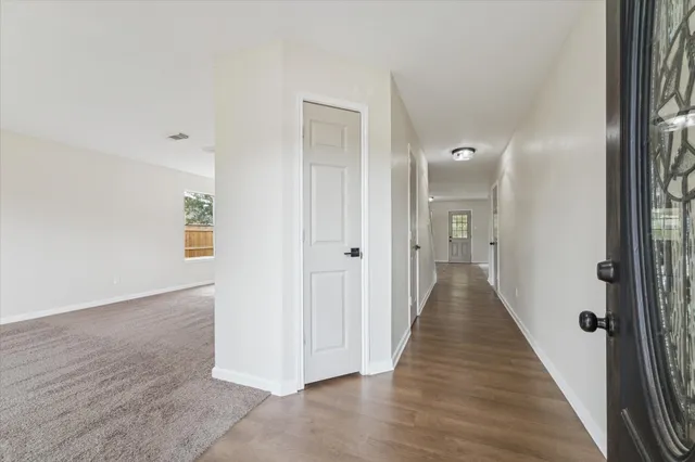 a view of a hallway with wooden floor