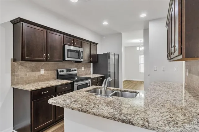 a kitchen with stainless steel appliances granite countertop a sink stove and refrigerator