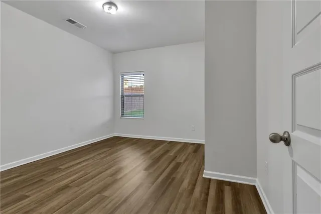 a view of a room with wooden floor and a window