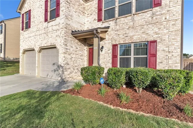 front view of a brick house with a yard