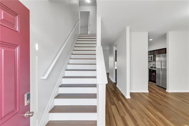 a view of staircase with white walls and wooden floor