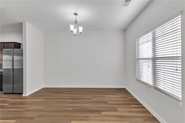 an empty room with wooden floor and window