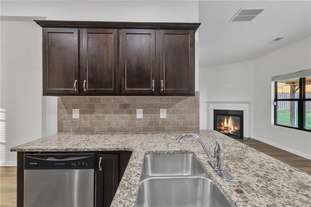 a kitchen with granite countertop a stove and a wooden cabinets