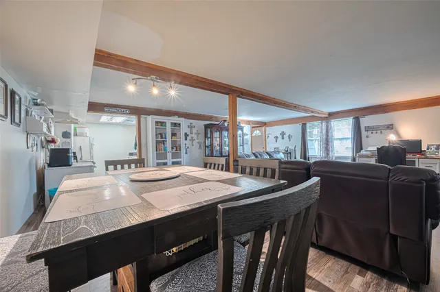a dining hall with stainless steel appliances granite countertop a sink dishwasher and a stove with wooden floor