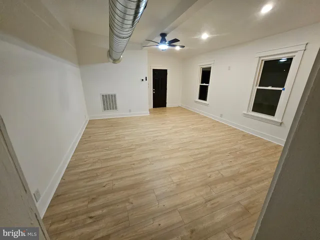 a big room with wooden floor and entryway