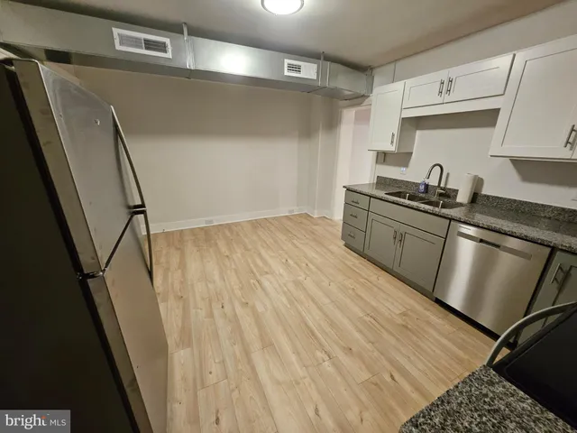 a kitchen with granite countertop a sink stove and refrigerator