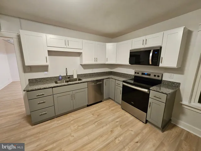 a kitchen with granite countertop a sink and steel appliances
