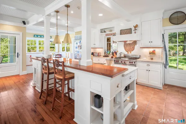 a kitchen with stainless steel appliances a table chairs sink and cabinets
