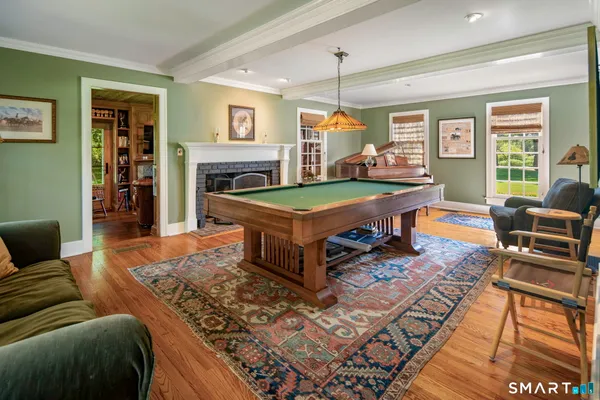 a living room with furniture pool table and a fireplace