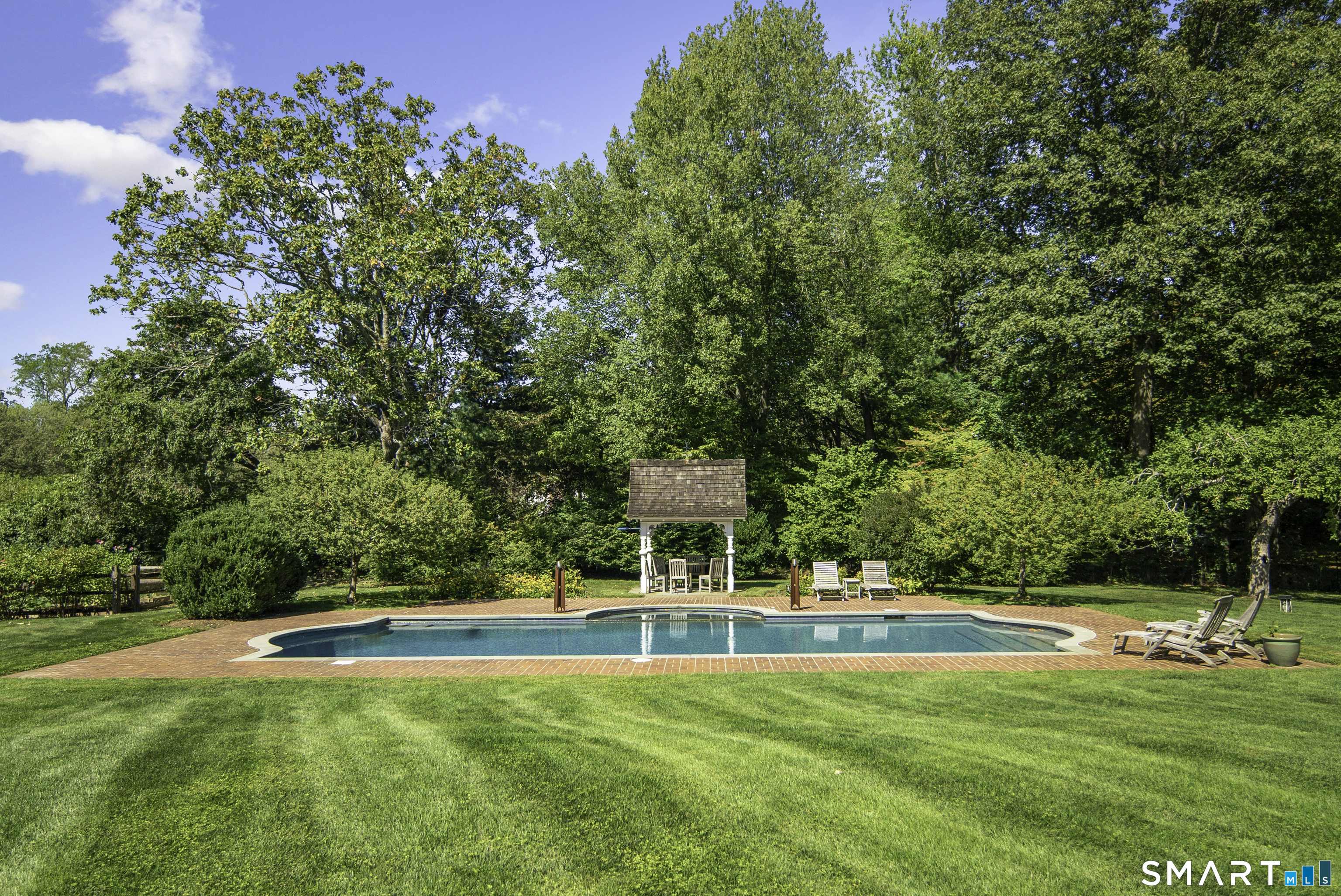198 Hemlock Hill Road New Canaan, CT 06840 - Photo 7 of 32 a view of a swimming pool with lawn chairs and large trees