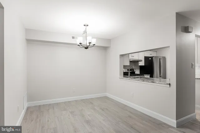 a view of a room with wooden floor kitchen and sink