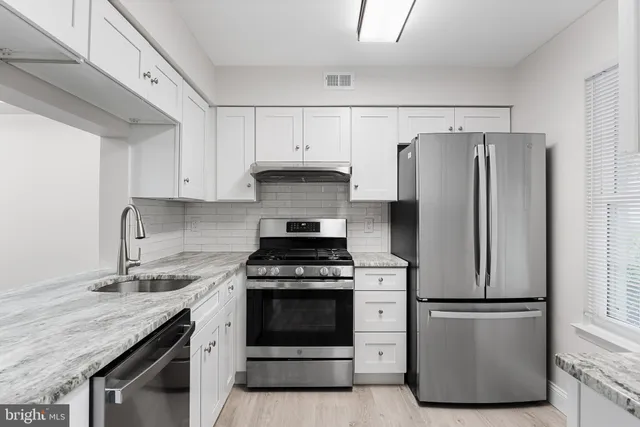a kitchen with a stove a refrigerator and a sink