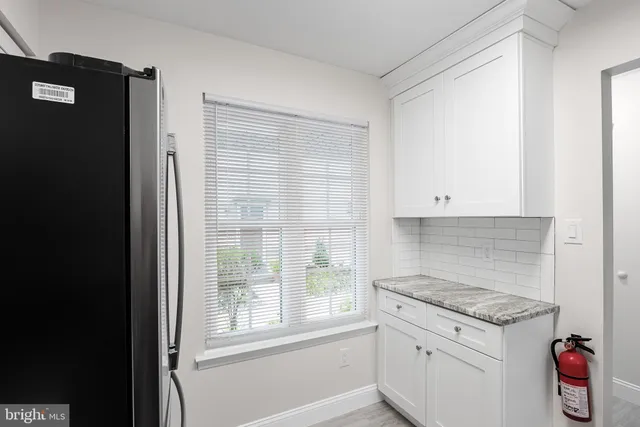 a kitchen with granite countertop a stove a sink and a refrigerator
