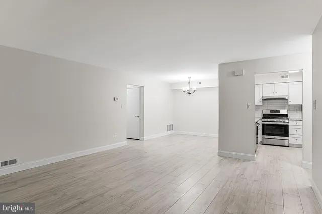 a view of a kitchen with wooden floor and electronic appliances